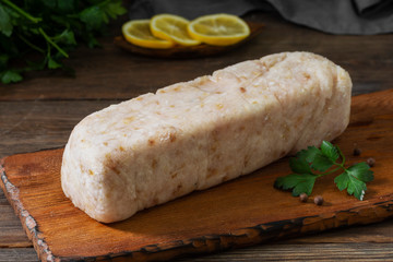Minced fish on a wooden Board on a brown wooden table. Minced meat in a briquette