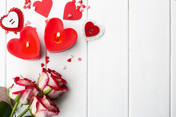 Red rose, hearts and romantic elements for Valentine's Day on a white wooden background