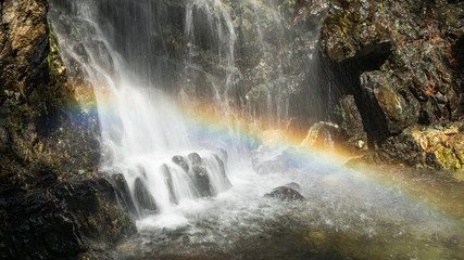 Fototapeta na wymiar Beautiful rainbow above the waterfall in forest. Mountains of troodos, Cyprus