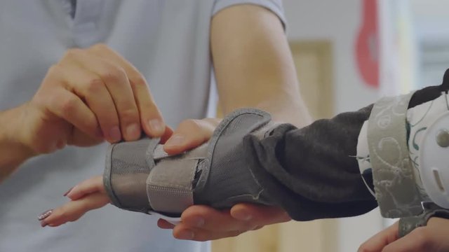 Close up of male hands putting protecting pad on female hand