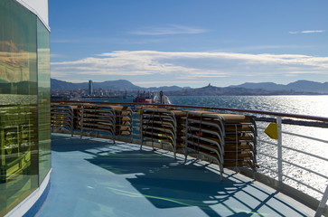 Deck on cruise ship or cruiseship liner with panoramic view of city of Marseille Provence on windy...