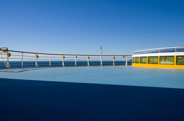 Open empty deck with railing and panoramic ocean view on cruiseship or cruise ship liner under blue...