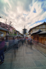 Naklejka premium Long exposure shot of historical street in Gion district with lot of tourists walking to the Yasaka pagoda in Kyoto, Japan.