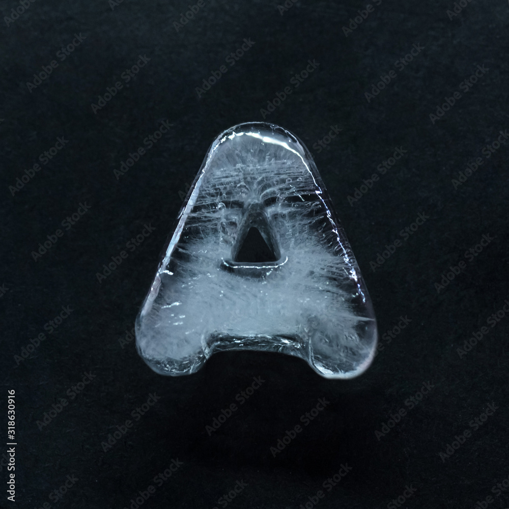 Fototapete melting speech. alphabet's shiny and well-structured letters made out of ice isolated on dark studio