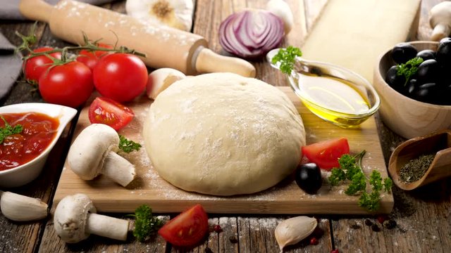 raw dough pizza on board with ingredient