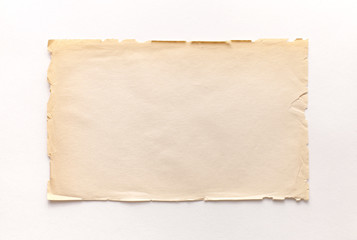 Old rough recycled paper with ragged edges on a white background with a shadow.