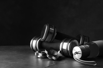 Gym equipment and accessories on stone floor against dark background
