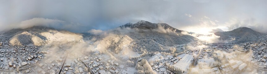 Aerial view of Krasnaya Polyana, mountains covered by snow and beautuful clouds. Russia.