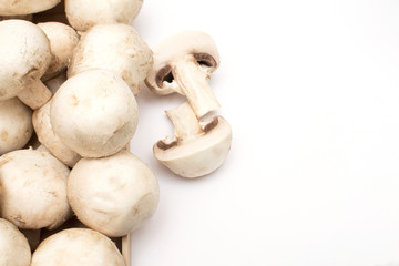 female hand takes champignon from a plate standing on a wooden kitchen board. White isolated layer with copy space.