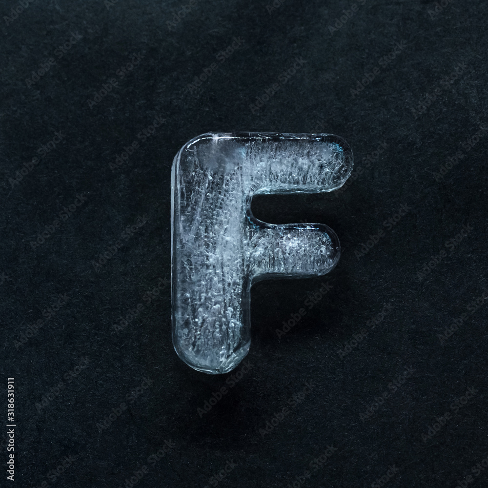 Fototapete melting speech. alphabet's shiny and well-structured letters made out of ice isolated on dark studio