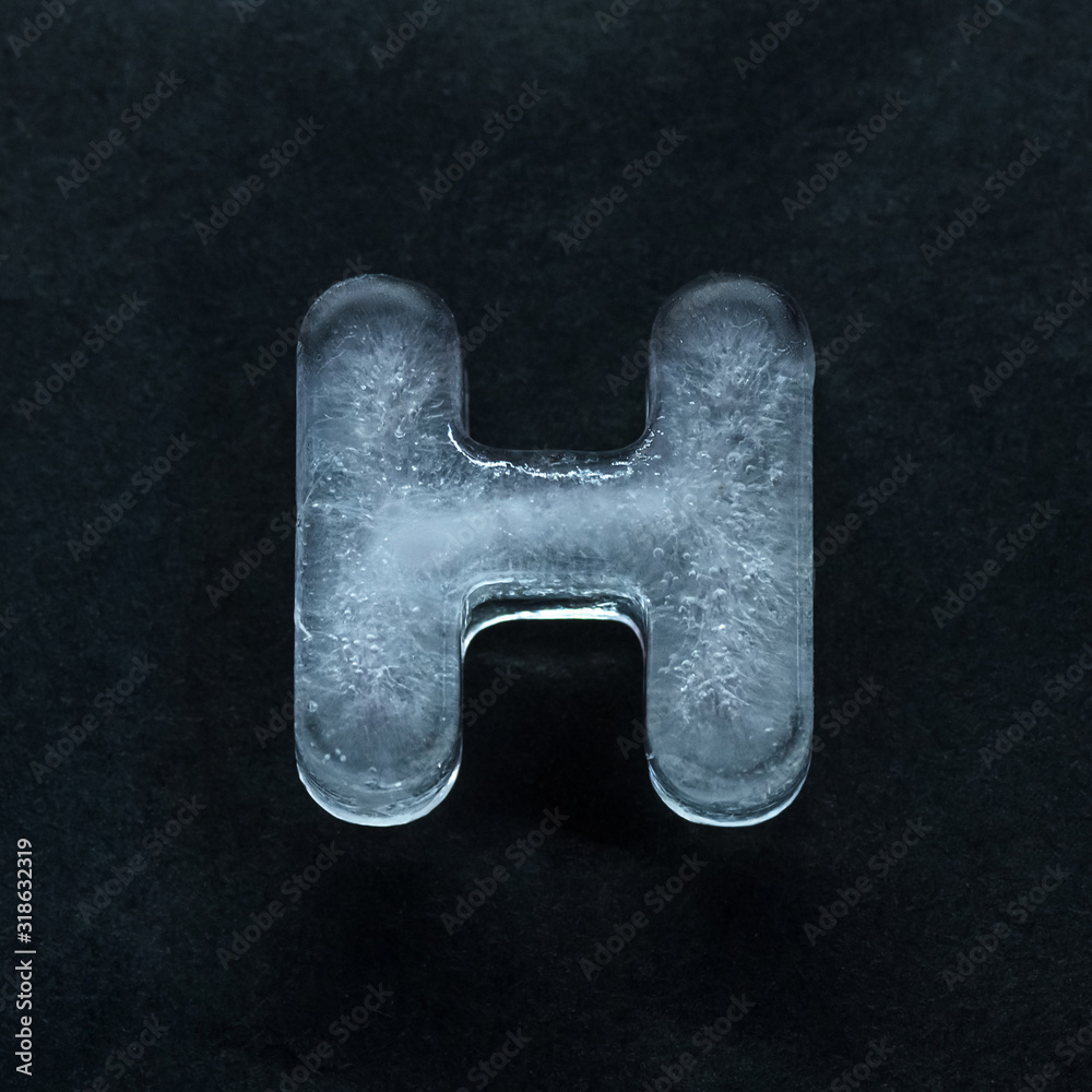 Fototapete melting speech. alphabet's shiny and well-structured letters made out of ice isolated on dark studio