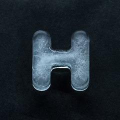 Melting speech. Alphabet's shiny and well-structured letters made out of ice isolated on dark...