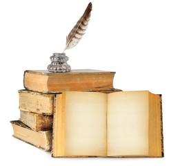 Isolated books with copy space. Ink bottle and quill on top of old books stack and one open book...
