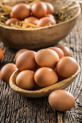 Fresh raw eggs in wooden bowl on rustic wooden table