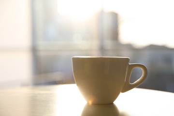 Cup of hot drink on table in morning. Space for text