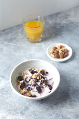 Bowl of granola with yogurt, nuts, cranberry and cocoanut. Concept for a tasty and healthy meal. Stone / wooden background. 