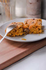 carrot cake with walnuts on a white plate