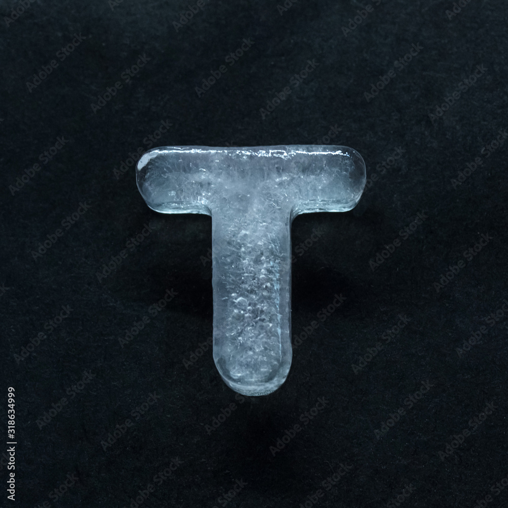 Fototapete melting speech. alphabet's shiny and well-structured letters made out of ice isolated on dark studio