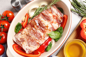Raw spare ribs with garnish on light table, closeup