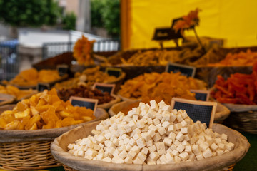Selling organic fresh agricultural product at farmer market. Fresh organic produce stall at a farmers market. Various dried fruits at the market in France . Selling and buying.