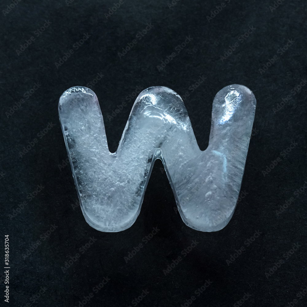 Fototapete melting speech. alphabet's shiny and well-structured letters made out of ice isolated on dark studio