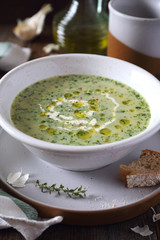 Spinach cream soup in ceramic plat, garlic and olive oil