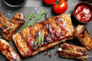 Delicious grilled ribs on black table, flat lay - obrazy, fototapety, plakaty