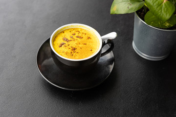 Serving of aromatic turmeric black coffee against dark table