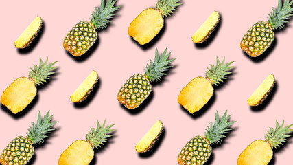 Creative pattern of fruit whole and slice pineapples with shadows on a soft pink color summer background. Clipping Path.