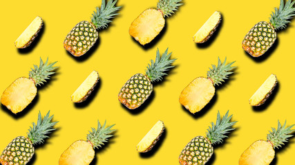 Creative pattern of fruit whole and slice pineapples with shadows on a bright yellow summer background. Clipping Path.