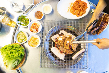 Overhead view of Korean barbecue being grilled, with other dishes