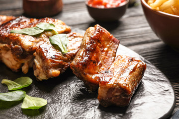 Delicious grilled ribs served on table, closeup