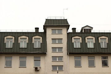 Fototapeta na wymiar green roof with an attic at the administrative modern building. many office windows