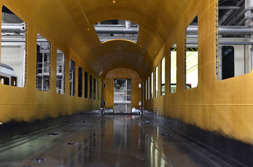 Inside of the rail car assembly plant. Industrial workshop for the production of high speed trains. Factory of the manufacturing trainsets passenger rolling stock. Paint shop