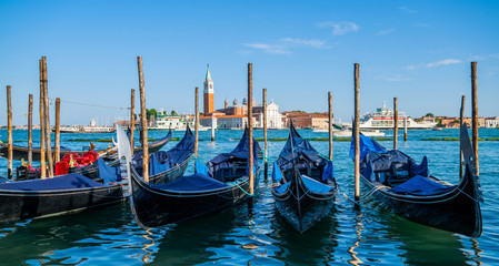 Fototapeta na wymiar Gondolas moored by Saint Mark square. Old pier. Architecture and landmarks of Venice. Vacation and holidays in Italy and Europe concept.