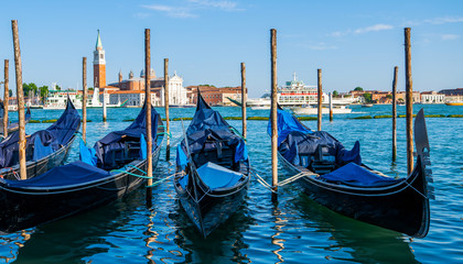 Gondolas moored by Saint Mark square. Old pier. Architecture and landmarks of Venice. Vacation and holidays in Italy and Europe concept.