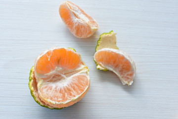  Natural, whole, chopped tangerines on wooden background