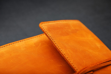 The album cover is made of brown genuine leather, handmade on a black background. Elements of a leather product close-up.