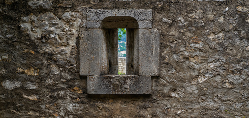 Medieval old stone castle wall with metal forging. Antique stone wall with traces of weathering and destruction.