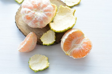  Natural, whole, chopped tangerines on wooden background
