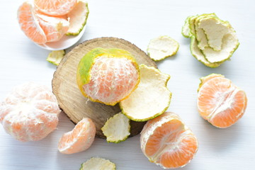  Natural, whole, chopped tangerines on wooden background