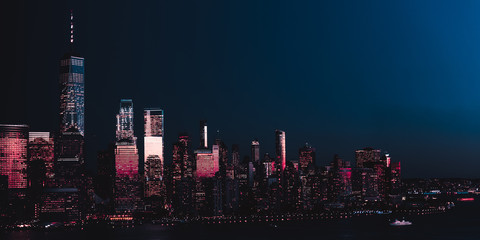Amazing panorama view on New York City skyline and Downtown Manhattan from Jersey City during night. Banner image - obrazy, fototapety, plakaty