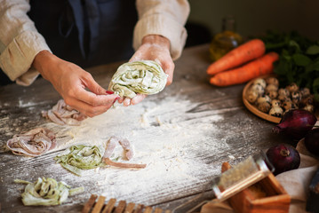 Process of making homemade pasta. Chef make fresh italian traditional pasta. Tasty appetizing classic italian pasta with tomato sauce, cheese parmesan, basil and vegetables on dark table.