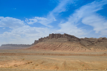 Fototapeta na wymiar Desert landscape with rocks and geological formations on a hot summer day on the road from Kerman to Mashhad.