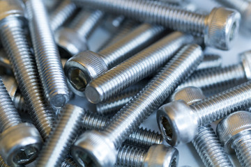Macro photo of chromed screws on a white background. Macro photo chromed screws, screw background, steel screw, selective focus.