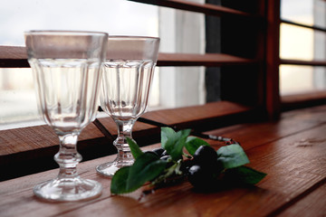 Window with a wooden cozy windowsill - empty glasses and flower decor