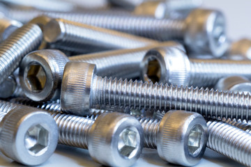 Macro photo of screws on a white background. Macro photo chromed screws, screw background, steel screw, selective focus.