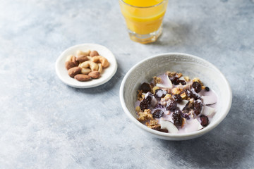 Bowl of granola with yogurt, nuts, cranberry and cocoanut. Concept for a tasty and healthy meal. Stone  background. 
