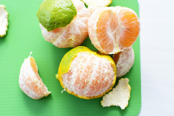  Natural, whole, chopped tangerines on wooden background