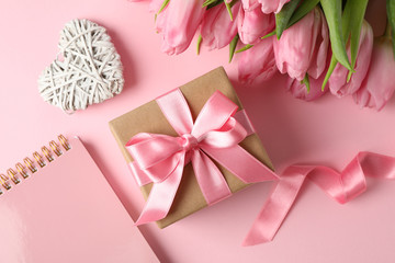 Tulips, gift, hearts and copybook on pink background, close up